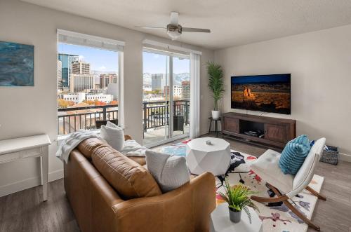 a living room with a couch and a tv at Stunning 1BD Pool, Htub, Gym Near Convention Centre in Salt Lake City