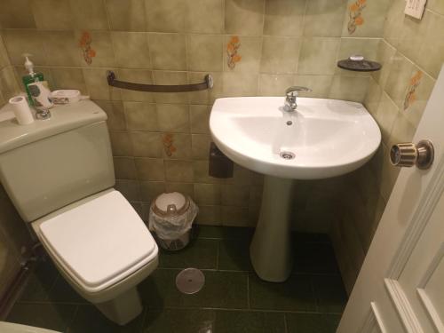a bathroom with a white toilet and a sink at Acogedora casa a pie de playa in Cillero