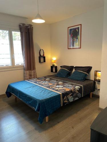 une chambre avec un lit avec une couette bleue dans l'établissement Appartement la Cayolle, à Barcelonnette