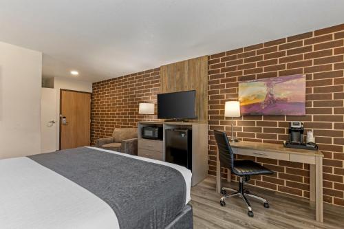a hotel room with a bed and a desk and a tv at Best Western Plus Waterloo & Cedar Falls in Waterloo