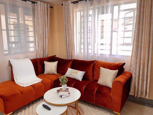 a brown couch in a living room with a table at Bella Homes Thika Town in Thika