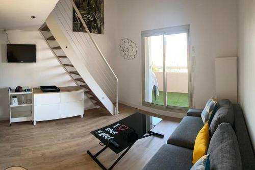 un salon avec un canapé et un escalier dans l'établissement Sainte Maxime, appt tout confort, à Sainte-Maxime