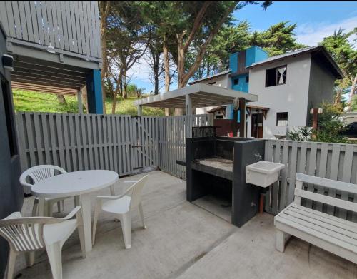 a patio with a table and chairs and a bench at Medanos in Las Gaviotas