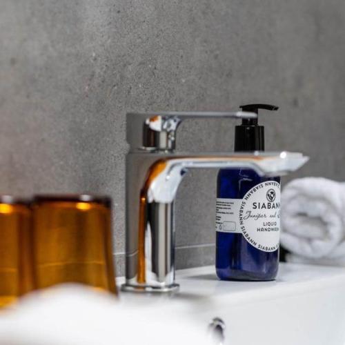 a bottle of soap sitting next to a bathroom sink at Ardeonaig Hotel & Restaurant in Ardeonaig