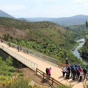 a group of people walking on a bridge over a river at CASA TAPADA DA CHEDA 2 in Celorico de Basto