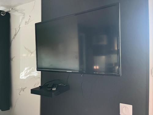 un téléviseur à écran plat accroché au mur dans l'établissement Logement proche de Disney, à Couilly-Pont-aux-Dames