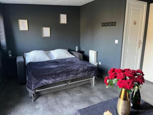 - une chambre dotée d'un lit avec des draps violets et des fleurs rouges dans l'établissement Logement proche de Disney, à Couilly-Pont-aux-Dames