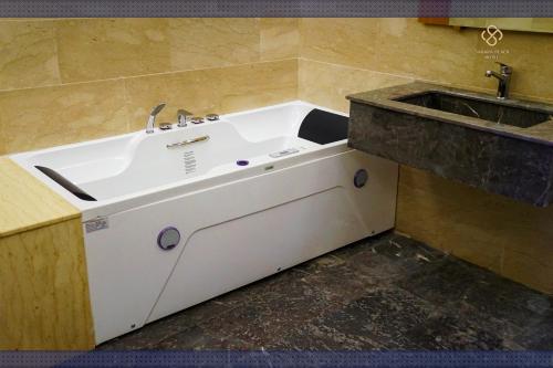 a bathroom with a sink and a bath tub at Sahara Beach in Tan-Tan Plage