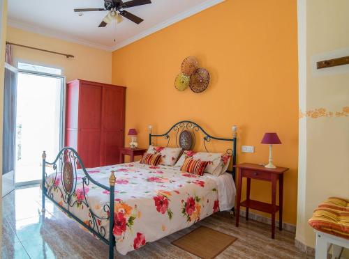 ein Schlafzimmer mit einem Bett und einem Deckenventilator in der Unterkunft La Casa de la Cascada in Anna