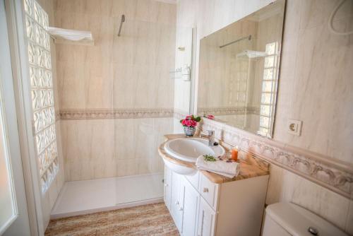 ein weißes Badezimmer mit Waschbecken und Spiegel in der Unterkunft La Casa de la Cascada in Anna