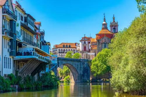 a bridge over a river in a city with buildings at CASA TAPADA DA CHEDA 2 in Celorico de Basto