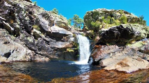 a waterfall on the side of a rocky mountain at CASA TAPADA DA CHEDA 2 in Celorico de Basto