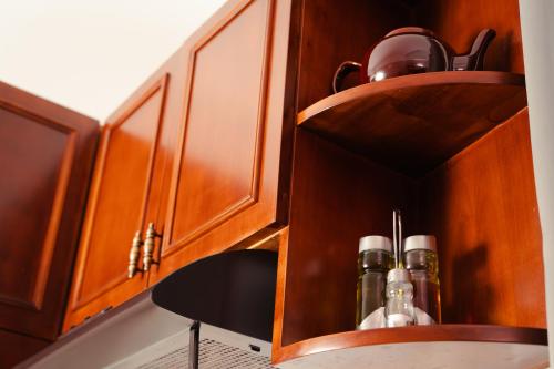 a wooden cabinet with bottles in it in a kitchen at Central House in Plaka in Athens
