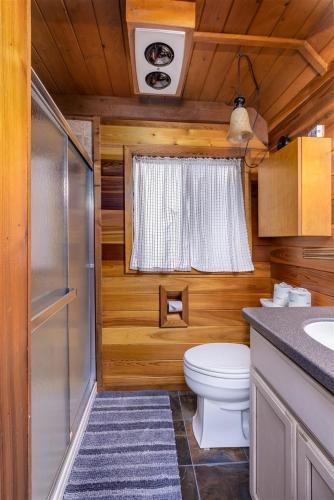 a small bathroom with a toilet and a sink at Elk Drop Inn | Wifi, Firepit, Smart TV in Packwood