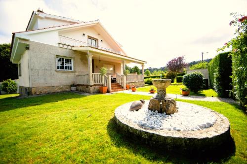 a house with a fountain in front of a yard at Casa Olivar El Mandarino in Orazo