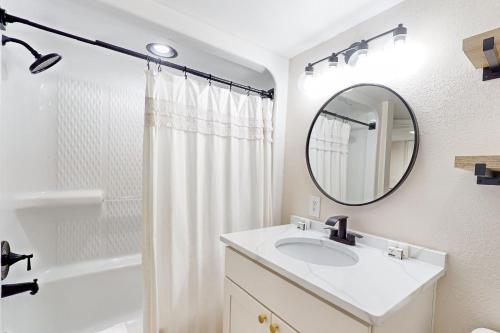 a white bathroom with a sink and a mirror at Sandy Daydreams, Unit PH3 in Myrtle Beach
