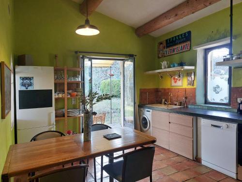une cuisine avec une table en bois et une salle à manger dans l'établissement Maison d'artiste, à Gargas
