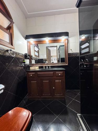 a bathroom with a sink and a mirror at Pousada Vale Valparaíso Inn- Polo gastronômico in Petrópolis