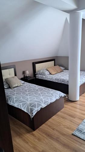 two beds in a room with wood floors at Noclegi Damianek in Nowy Targ