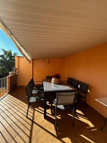 a dining room with a table and chairs on a deck at Casa Bretalunya in Benissanet
