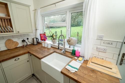 a kitchen with a sink and a window at -- Huge -- 5-bedroom home & Private Gym by Tailored Accommodation in Swansea