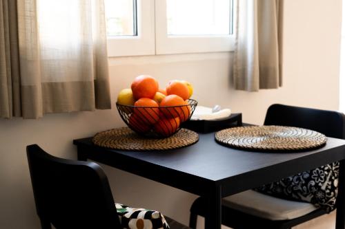 a bowl of fruit sitting on a black table at Central House in Plaka in Athens