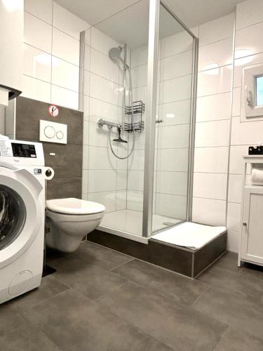 a bathroom with a shower with a toilet and a sink at COVE Appart in Hard