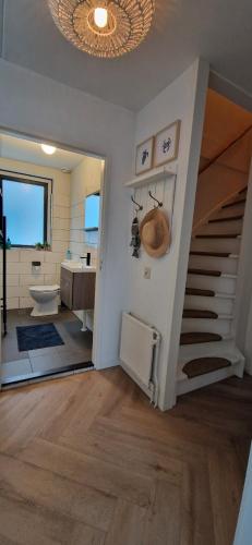 a bathroom with a staircase and a sink and a bathroom with a tub at Lakestyle wellness met hottub en BBQ bij meer in Gelderland in Ewijk