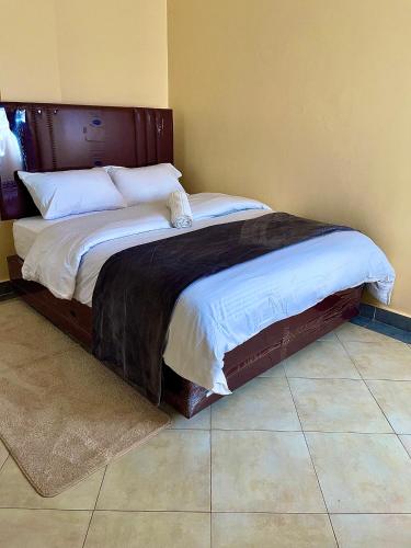 a bed with a wooden headboard in a bedroom at Bella Homes 2br Thika Town in Thika