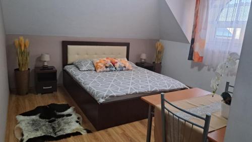 a bedroom with a bed and a table with a dog on it at Noclegi Damianek in Nowy Targ