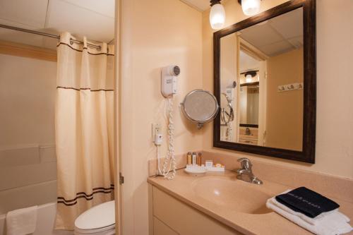 uma casa de banho com um lavatório, um WC e um espelho. em Reges Oceanfront Resort em Wildwood Crest