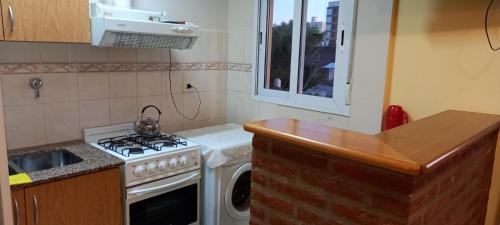 een keuken met een fornuis en een wasmachine bij Tres Ciudades in Monte Hermoso