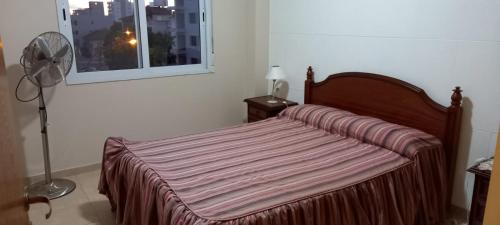 een bed in een kamer met een ventilator en een raam bij Tres Ciudades in Monte Hermoso