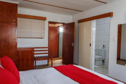 a bedroom with a bed and a bathroom at Haus Garnison B&B in Swakopmund