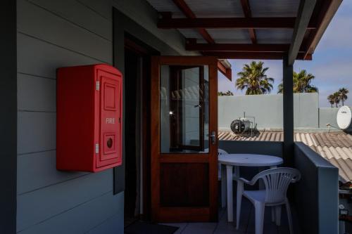 a red mailbox on the side of a house with a table at Haus Garnison B&B in Swakopmund
