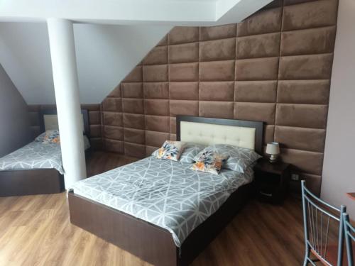 two beds in a bedroom with a large wall at Noclegi Damianek in Nowy Targ