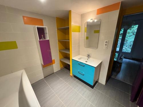 La salle de bains est pourvue d'une armoire bleue et d'un lavabo. dans l'établissement maison loft au pied du Luberon, à Cavaillon