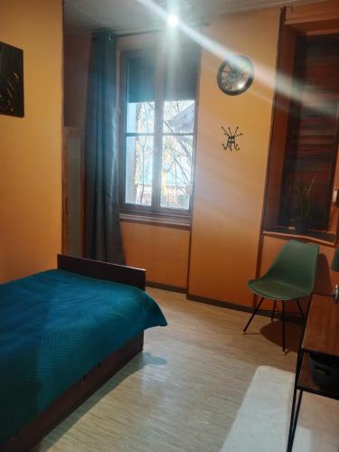 une chambre avec un lit, une fenêtre et une chaise dans l'établissement Pounette T3 villa appt rdc 2 chambres thermes centre, à Luxeuil-les-Bains