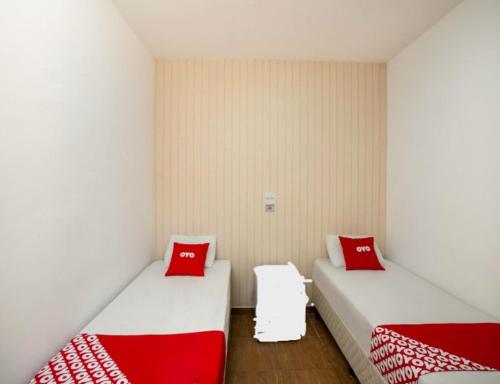2 camas en una habitación con almohadas rojas. en Hotel Vintage SP, en São Paulo
