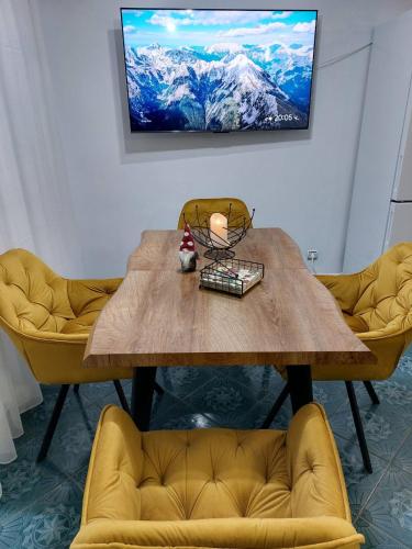 a wooden table with two yellow chairs in a room at Tsvetanov Apartment in Blagoevgrad
