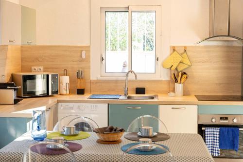 a kitchen with a table with dishes on it at Appartement avec piscine et jacuzzi à 50mètres de la plage et 5min de l'allée des Pins in Argelès-sur-Mer