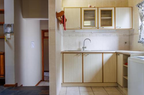 a kitchen with wooden cabinets and a sink at Haus Garnison B&B in Swakopmund