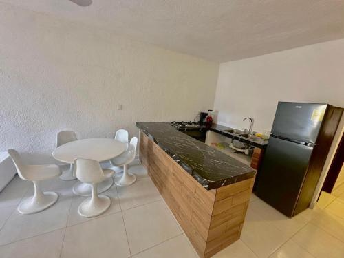 a kitchen with a table and chairs and a refrigerator at Depto #20, a unos pasos de la playa Las Brisas in Manzanillo