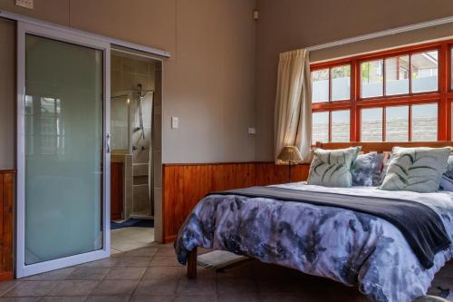 a bedroom with a large bed and a shower at Haus Garnison B&B in Swakopmund