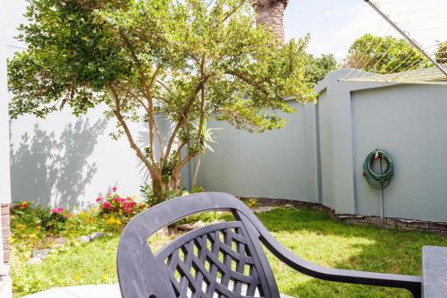 a bench sitting in a yard next to a tree at Haus Garnison B&B in Swakopmund