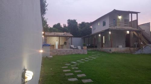 a backyard with a house and a stone pathway at Vianna's House in Buzios