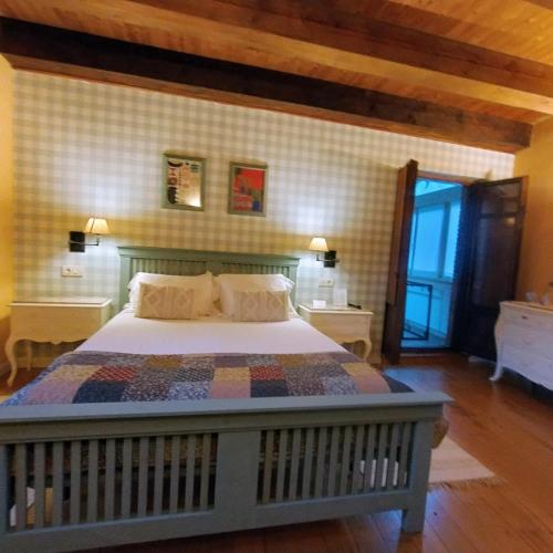 a bedroom with a bed and two tables and a window at Hotel Boutique Villa de Palacios - Palacio de Aras in San Miguel de Aras