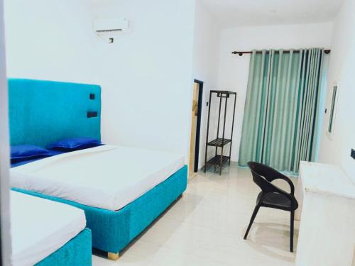 a bedroom with a bed and a chair in it at Wimal Wood Stock Surf House in Weligama