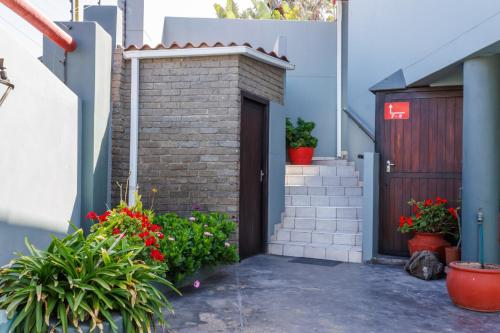 a brick house with a door and some flowers at Haus Garnison B&B in Swakopmund