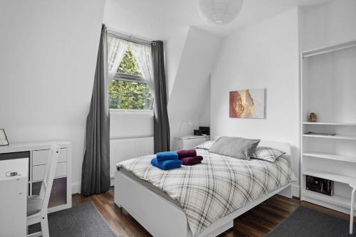 a bedroom with a white bed and a window at Modern Spacious Rooms 10 Minutes from Big Ben in London